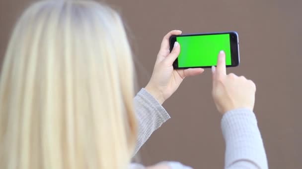 Kız mobil bir cihazla. Yeşil arka plan, renk anahtar — Stok video