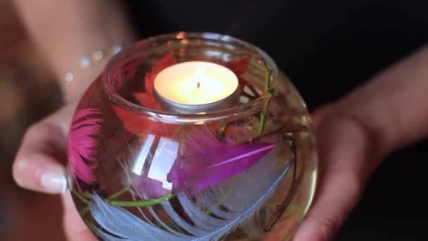 Womens handen houd een glas kolf met brandende kaarsen en decor binnen haar — Stockvideo