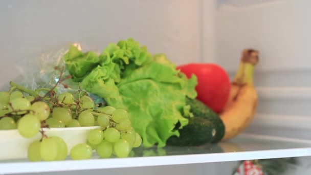 Mans hand neemt fruit uit de koelkast — Stockvideo