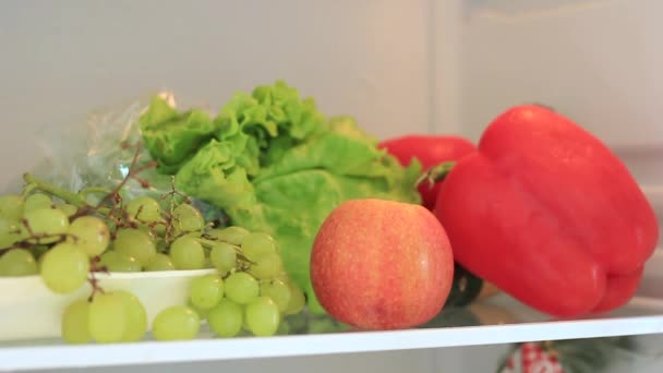 Mans hand neemt fruit uit de koelkast — Stockvideo