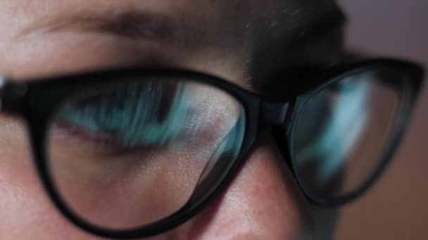 Ogen van een meisje met bril kijken naar een close-up van de monitor — Stockvideo