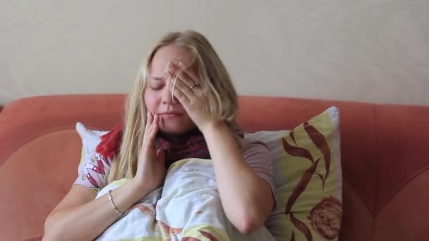 Young girl has flu and looks at a thermometer — Stock Video