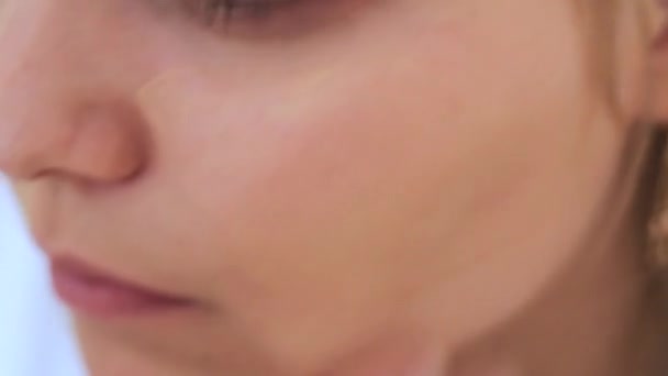 Девушка наносит макияж на лицо — стоковое видео