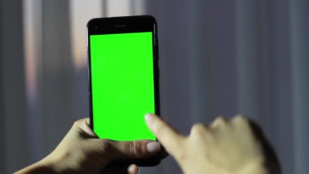 Le mani delle ragazze che tengono un telefono cellulare con uno schermo verde. Chiave Hroma — Video Stock