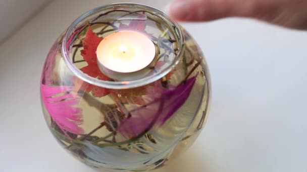 Mano de las mujeres pone una vela en un frasco con agua y decoraciones — Vídeos de Stock