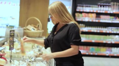 kız bir süpermarkette peynir seçer