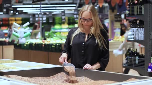 Meisje in de winkel gaat over boekweit — Stockvideo