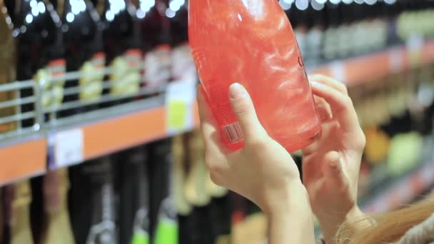 Mão feminina segurando uma garrafa de vinho alcoólico — Vídeo de Stock