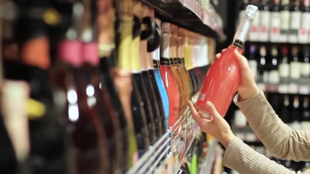 Mano femenina con una botella de alcohol — Vídeo de stock
