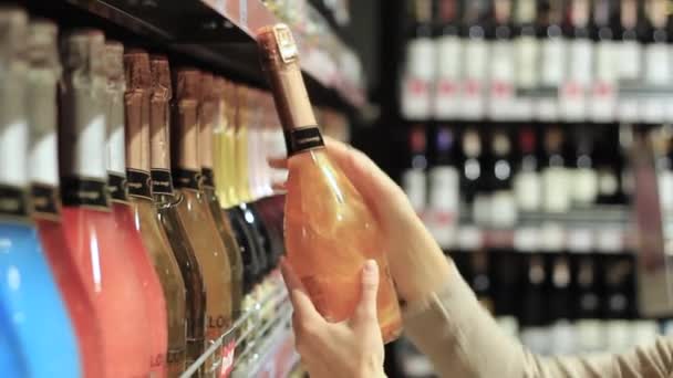 Vrouwelijke hand met een fles alcohol — Stockvideo