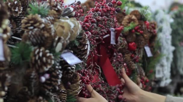 Γυναικεία χέρια εξετάζουν ένα στεφάνι Χριστουγέννων χειροποίητο έργο — Αρχείο Βίντεο