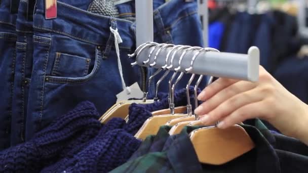 Mujer elegir pastel cálidos y acogedores suéteres en perchas — Vídeo de stock