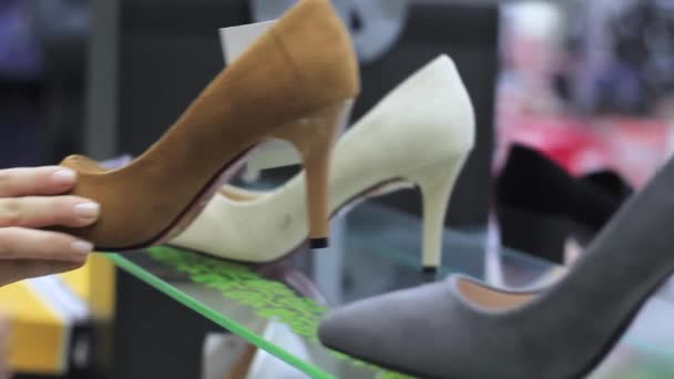 A fare shopping. Le mani femminili scelgono scarpe con i tacchi nel negozio — Video Stock