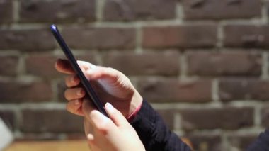 El ele tutuşmak için cep telefonu kullanın. Kız akıllı telefon kullanıyor..