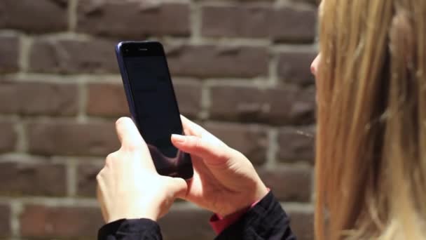 Celebración de la mano usando el teléfono móvil phone.girl usando el teléfono inteligente. — Vídeos de Stock