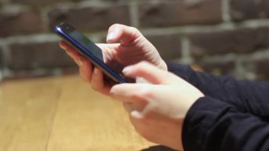 El ele tutuşmak için cep telefonu kullanın. Kız akıllı telefon kullanıyor..