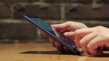 El ele tutuşmak için cep telefonu kullanın. Kız akıllı telefon kullanıyor..