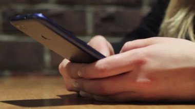 El ele tutuşmak için cep telefonu kullanın. Kız akıllı telefon kullanıyor..