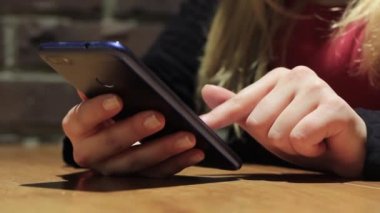 El ele tutuşmak için cep telefonu kullanın. Kız akıllı telefon kullanıyor..
