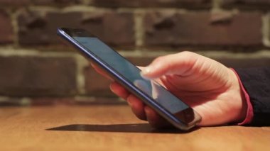 El ele tutuşmak için cep telefonu kullanın. Kız akıllı telefon kullanıyor..