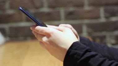 El ele tutuşmak için cep telefonu kullanın. Kız akıllı telefon kullanıyor..