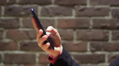 El ele tutuşmak için cep telefonu kullanın. Kız akıllı telefon kullanıyor..