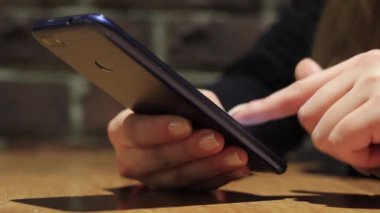 El ele tutuşmak için cep telefonu kullanın. Kız akıllı telefon kullanıyor..