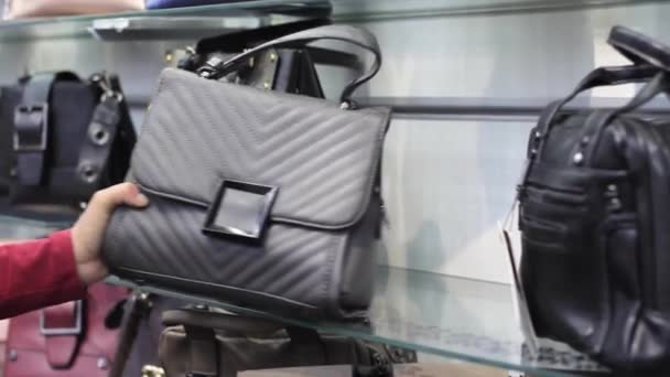 Female hands chooses a female handbag in the store — Stock Video