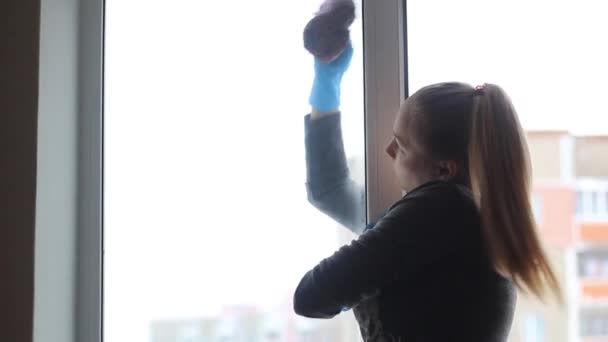 Mädchen wäscht Fenster in der Wohnung. — Stockvideo