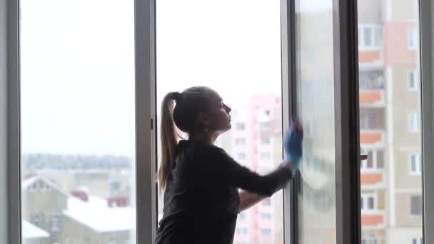 Mädchen wäscht Fenster in der Wohnung. — Stockvideo