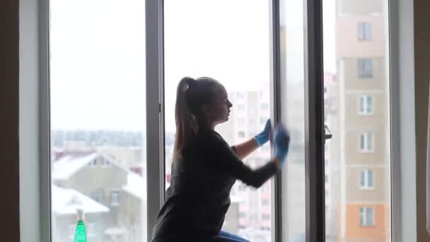 Девушка моет окно в квартире . — стоковое видео