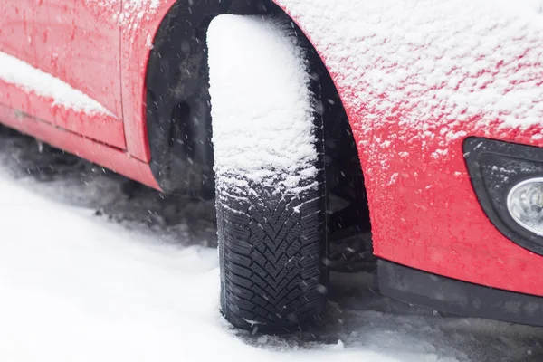 Närbild av bildäck på vintern på vägen täckt med snö — Stockfoto