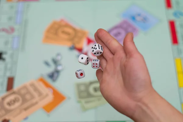 Female hand throws dice in a board game close up — Stock Photo, Image