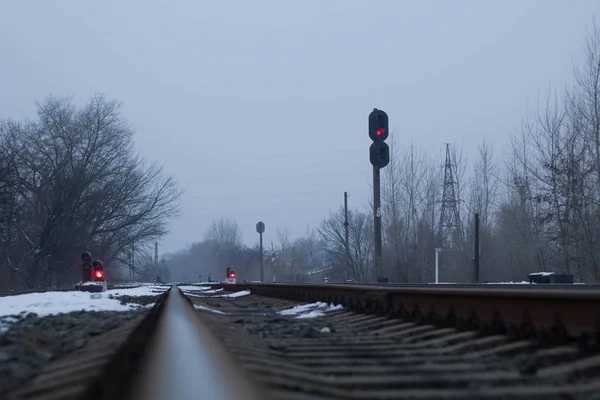 Semaforo sulla ferrovia in inverno, rosso brillante. Scena cupa — Foto Stock