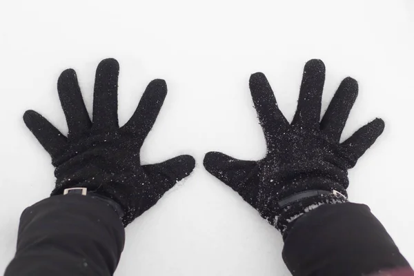 Kobiecych rąk w czarne rękawiczki w śniegu z bliska — Zdjęcie stockowe