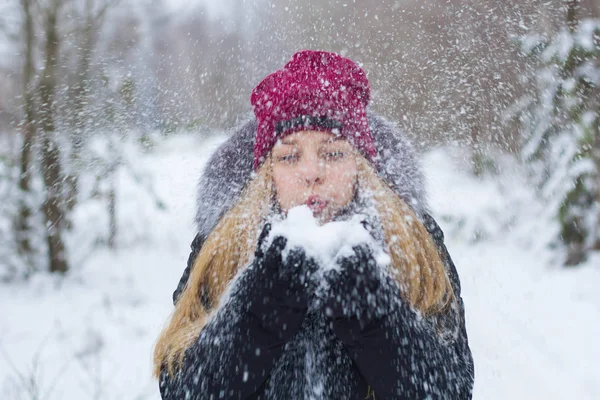 Dziewczyna cieszy się i wyrzuca śnieg zimą — Zdjęcie stockowe