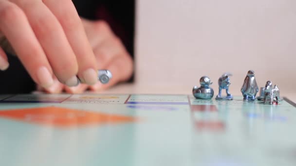 A játék a monopoly közelről. Női kéz tesz lépéseket a játék — Stock videók