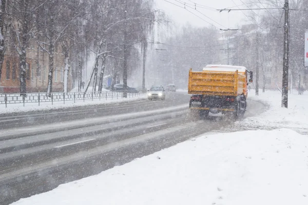 Samochody na zaśnieżonej drodze, na których spadnie śnieg — Zdjęcie stockowe