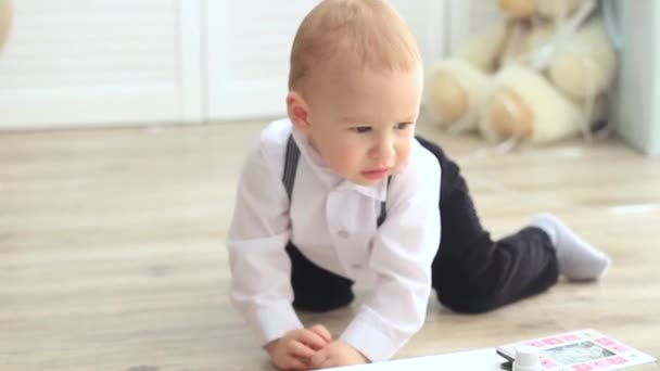 Малыш в костюме играет на полу — стоковое видео
