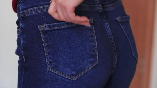 Kvinnlig hand klättrar i fickan på jeans på röven — Stockvideo