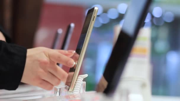 La mano femenina toca la pantalla del dispositivo móvil en la tienda — Vídeos de Stock