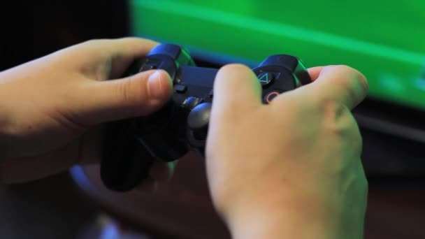 Il ragazzo tiene in mano un joystick da gioco e gioca a calcio. Schermo sfocato del monitor . — Video Stock