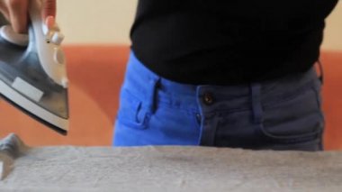 Kız ütü tahtası üzerinde demir ile giysi ütülü