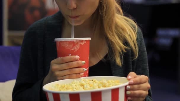 Chica comiendo palomitas de maíz y bebiendo una bebida — Vídeo de stock