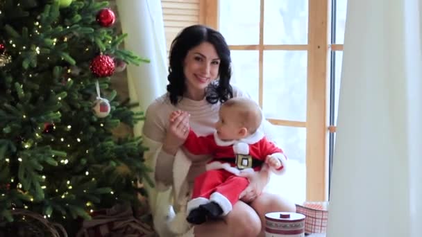 Μαμά με ένα μικρό παιδί με τα ρούχα του Αϊ Βασίλη για τα Χριστούγεννα — Αρχείο Βίντεο