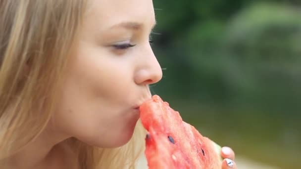 Женщина ест арбуз в природе близко — стоковое видео