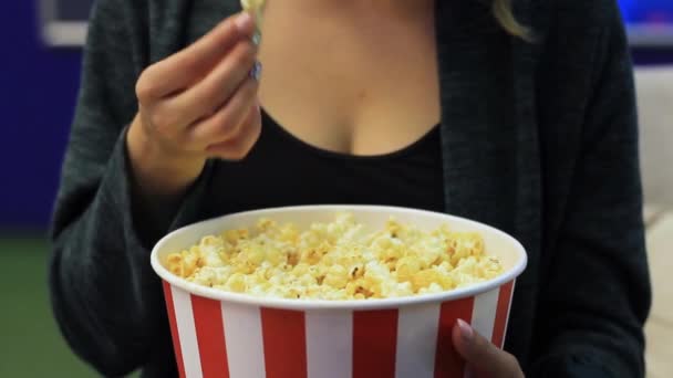 Unrecognizable woman eating popcorn at the cinema. — Stock Video