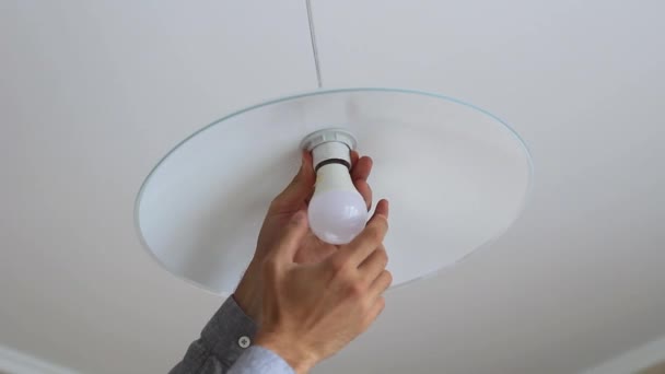 Zavření mužského ručního zkroutit LED lampa do stropního světla . — Stock video