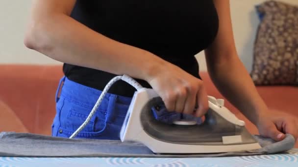 Mujer sonriente planchando ropa usando hierro en la tabla de planchar después de lavar en casa — Vídeos de Stock