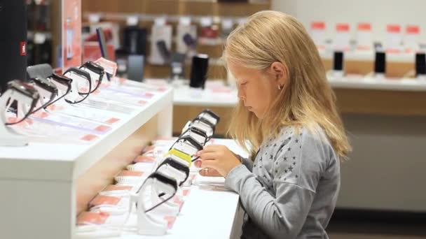 Kleines Mädchen in einem Armbanduhrengeschäft. smarte Uhr — Stockvideo